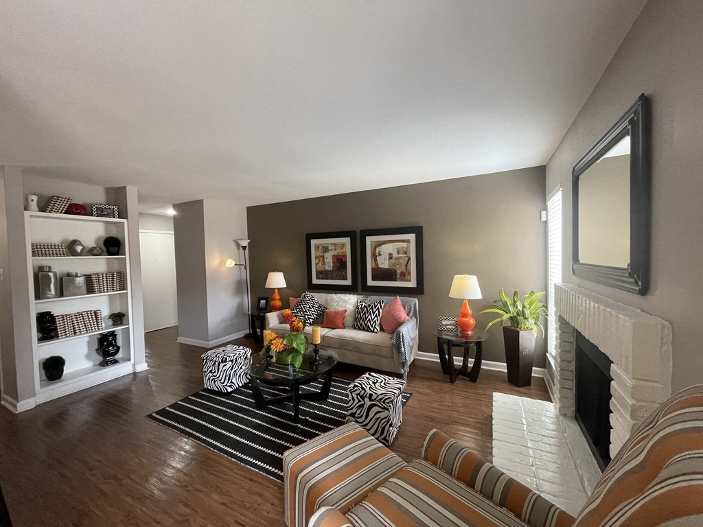 a living room with a fireplace and a striped couch at Oaks of Westchase, Texas, 77042