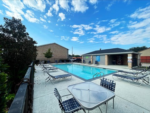 Swimming pool with lounge chairs and poolhouse at The Alara Apartments, Texas, 77060