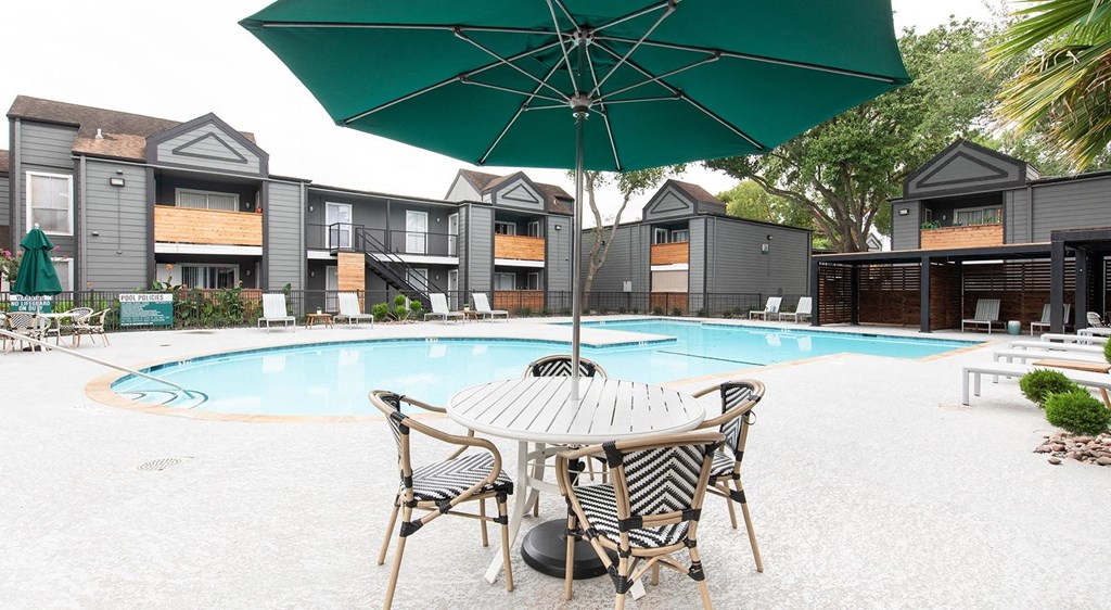 our apartments have a pool and a patio with a table and chairs
