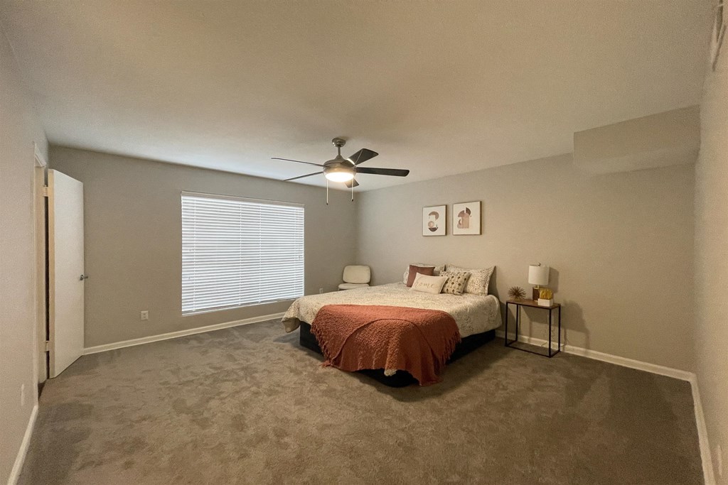 a bedroom with a bed and a ceiling fan