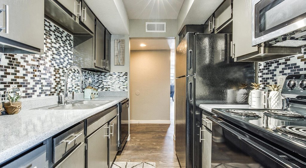 a kitchen with stainless steel appliances and white counter tops