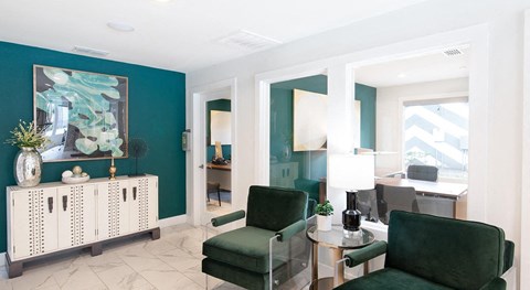 a living room with green chairs and a blue wall