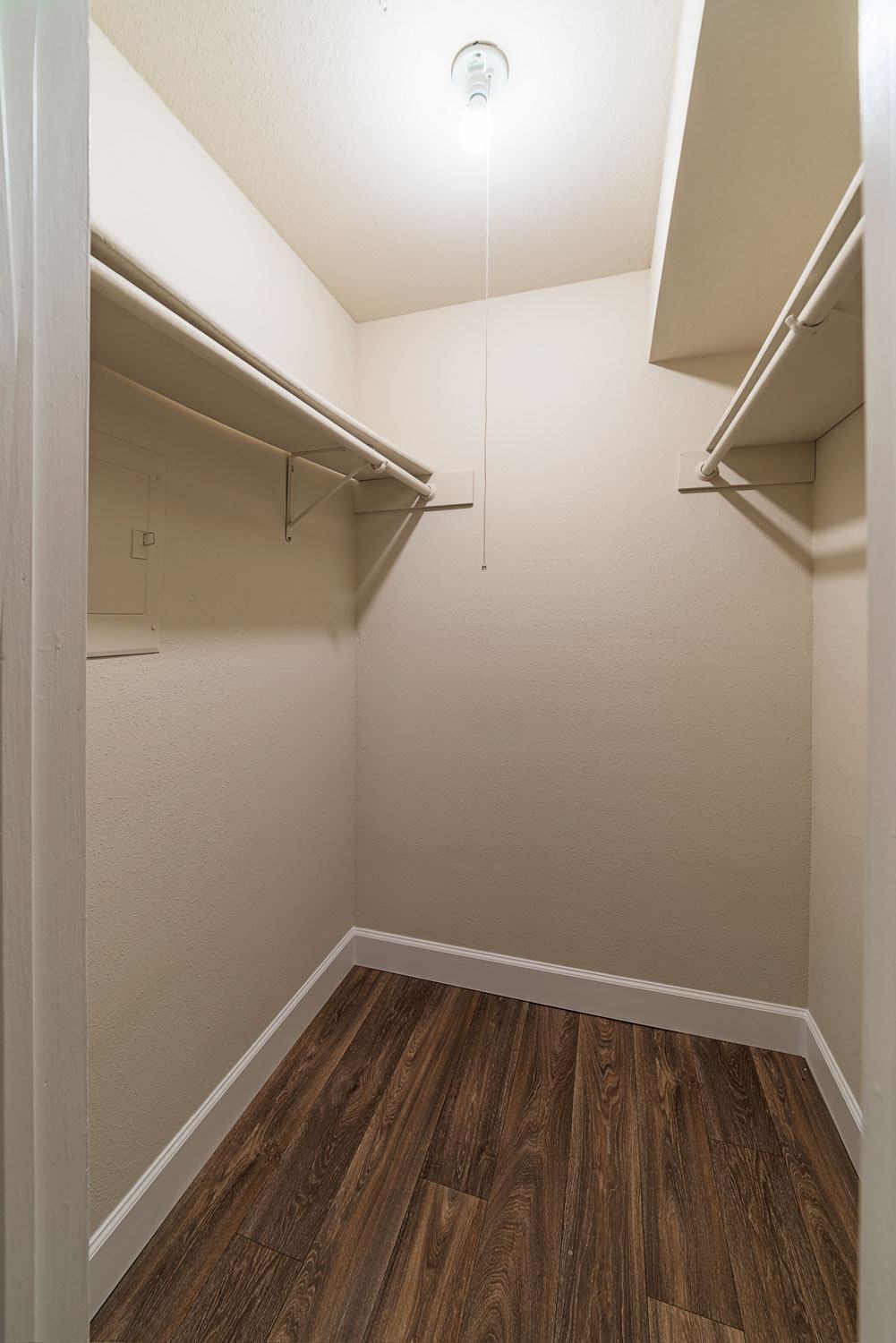 a spacious bedroom with a closet and a hanging light
