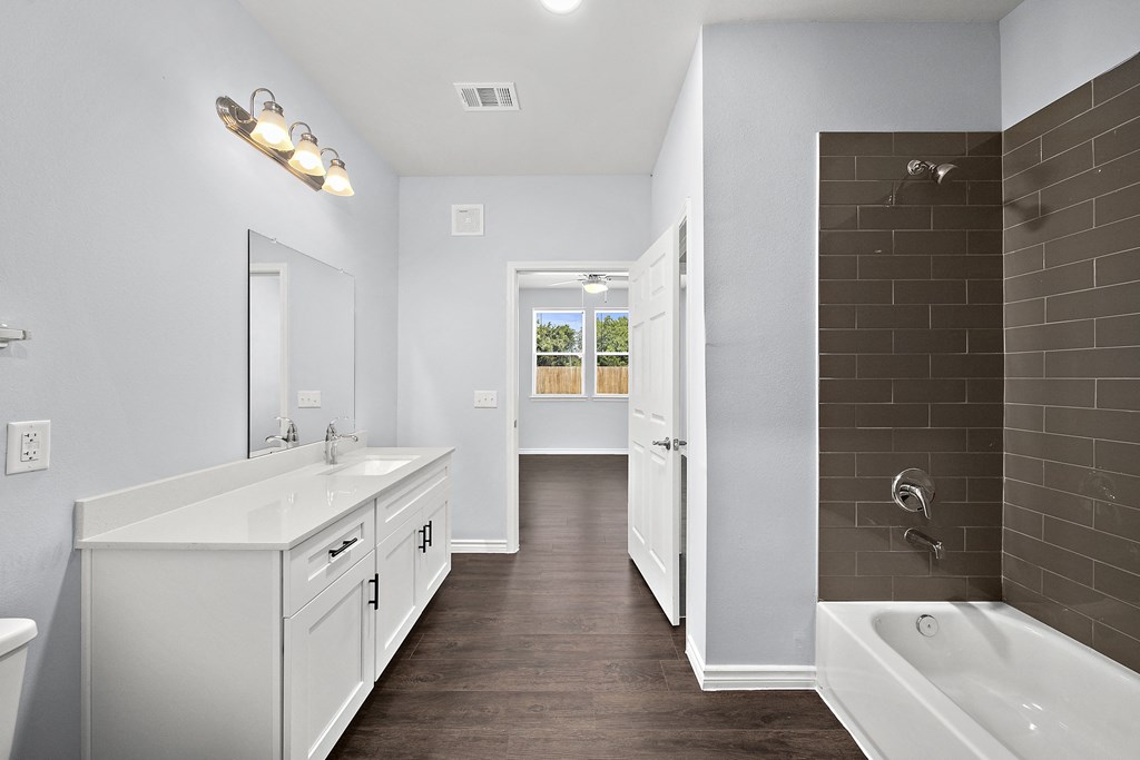 a white bathroom with a tub and a sink and a shower