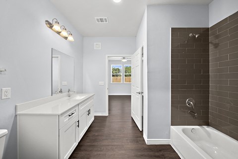 Master bathroom with double vanity and tiled shower at The Aurea Apartments, Houston, Texas