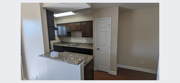 a kitchen with granite countertops and a white door