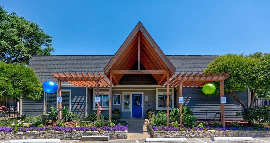 A house with a blue door and a wooden roof with a pergola.