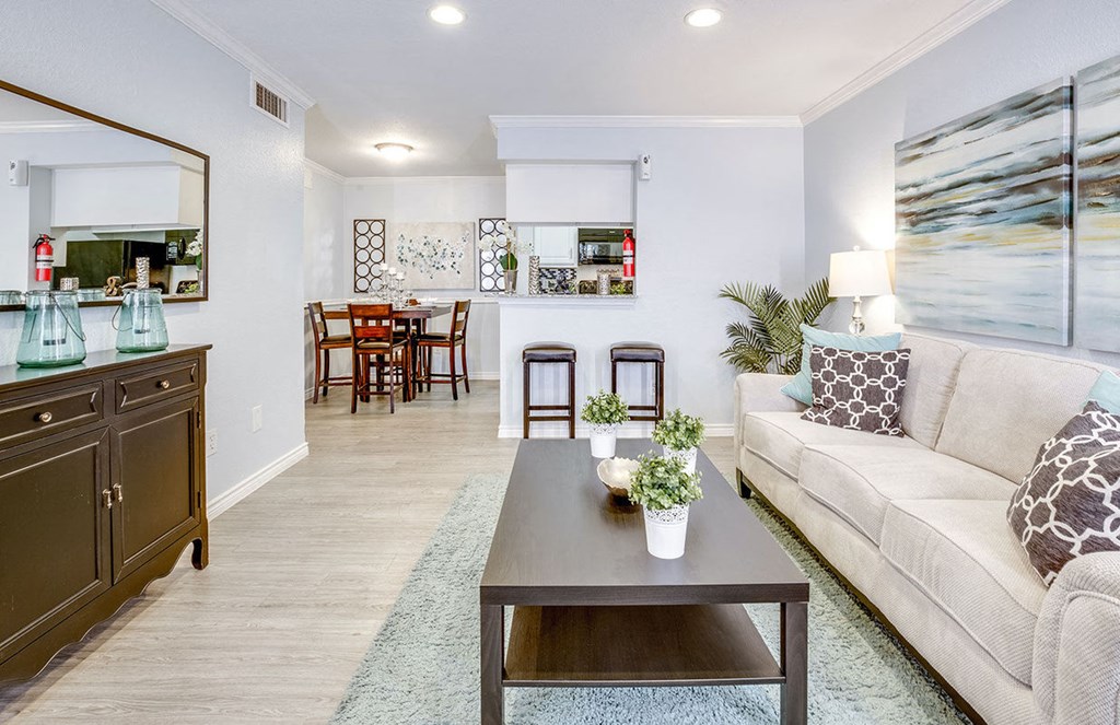 A living room with a couch, coffee table, and a dining table.
