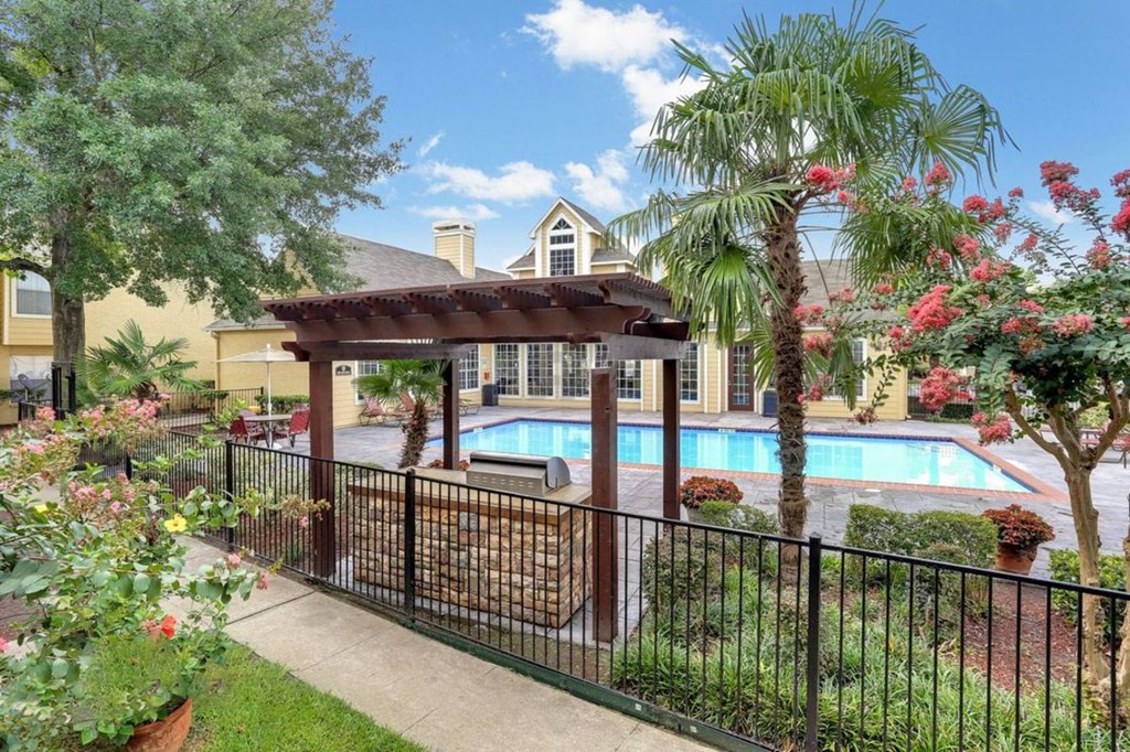 A pool area with a black fence and a gazebo.