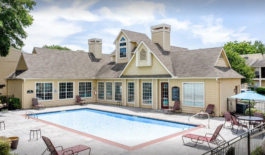 A house with a pool in front of it.