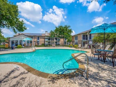 our apartments have a resort style pool with chairs and umbrellas