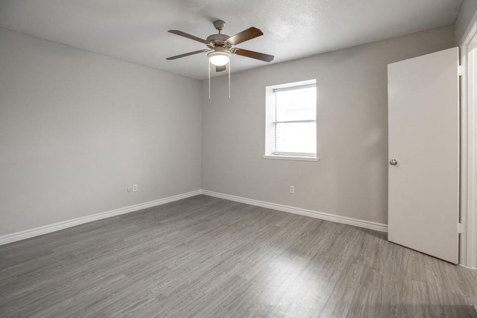 A room with a ceiling fan and a window.