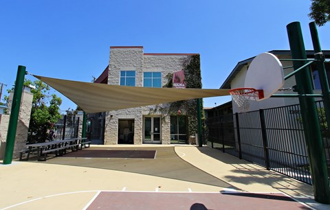 a basketball court in front of a building with a basketball hoop