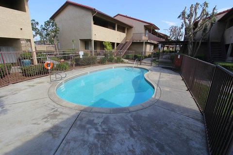 A small pool in a courtyard surrounded by a fence.