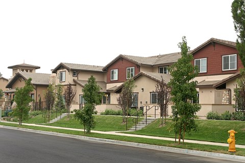 A row of houses with a yellow fire hydrant in front of them.