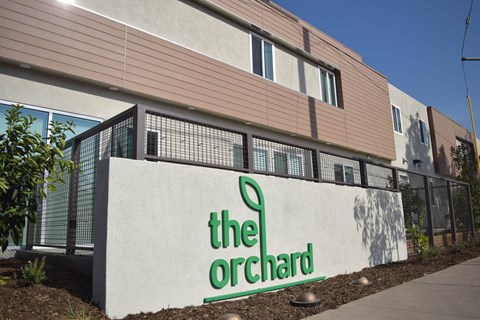 The Orchard building has a white sign with green lettering.