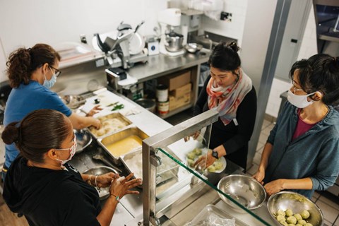 Four women are working in a kitchen.