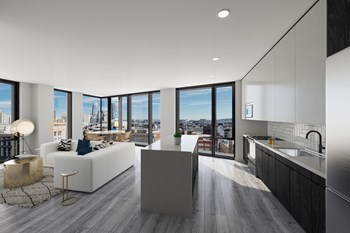 kitchen with dark cabinets and open living space with lots of windows
