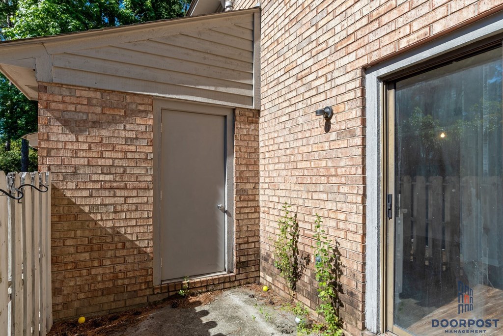 the front door of a brick house with a gray door