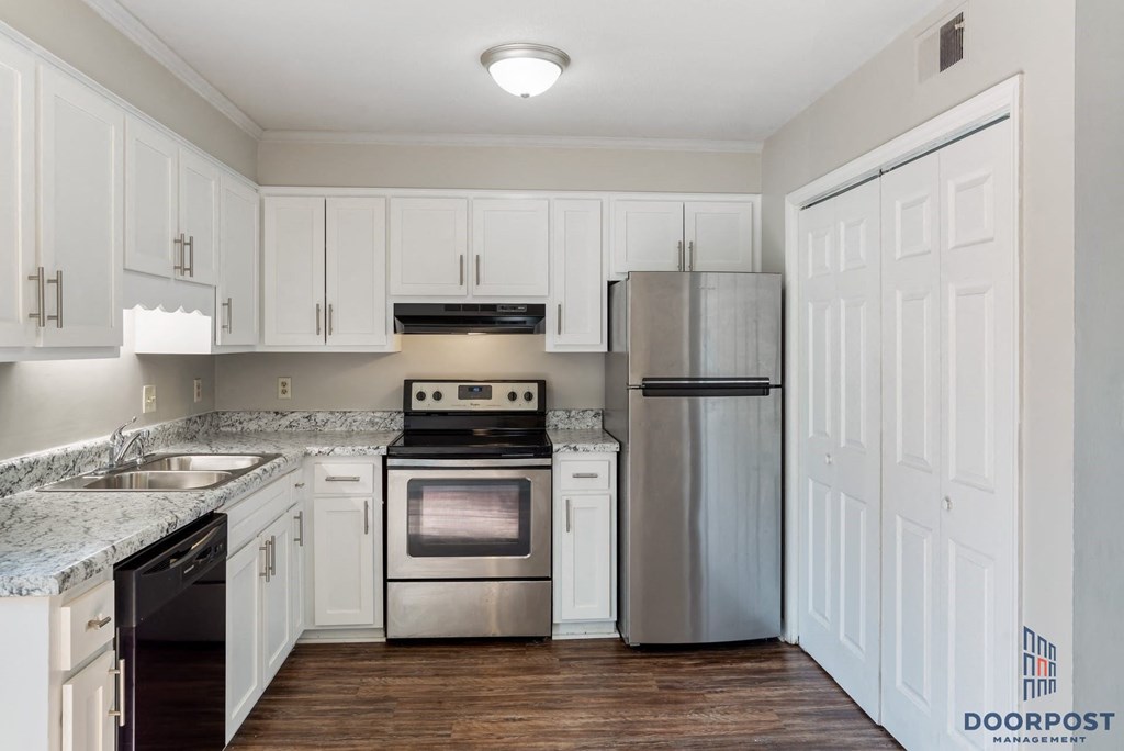 a kitchen with white cabinets and stainless steel appliances