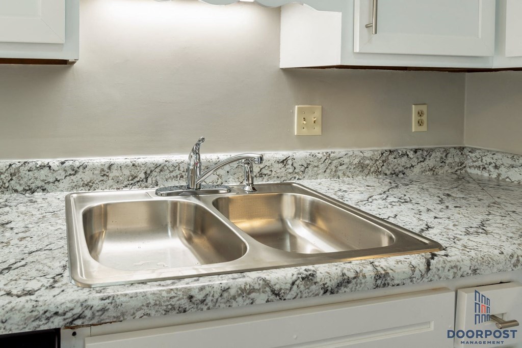 a stainless steel sink in a granite counter top