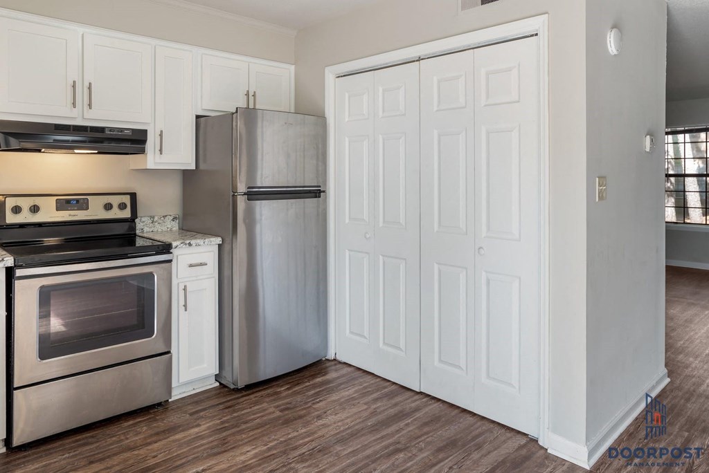 a kitchen with stainless steel appliances and white cabinets