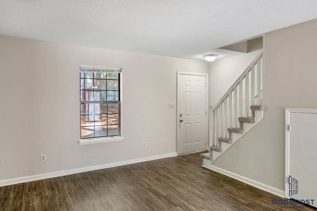 the living room and staircase of a new home with a white door