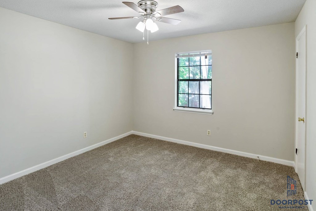 a bedroom with carpet and a ceiling fan
