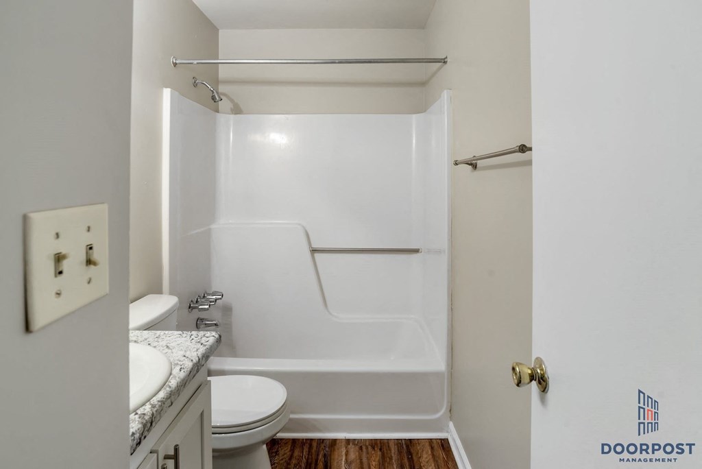 a bathroom with a toilet and a tub and a sink