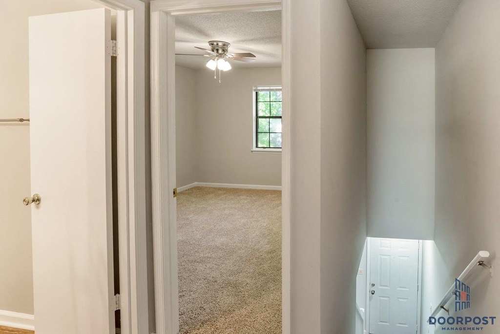 an empty bedroom with a closet and a ceiling fan