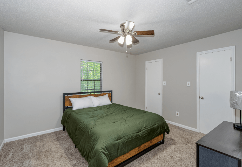 a bedroom with a bed and a ceiling fan