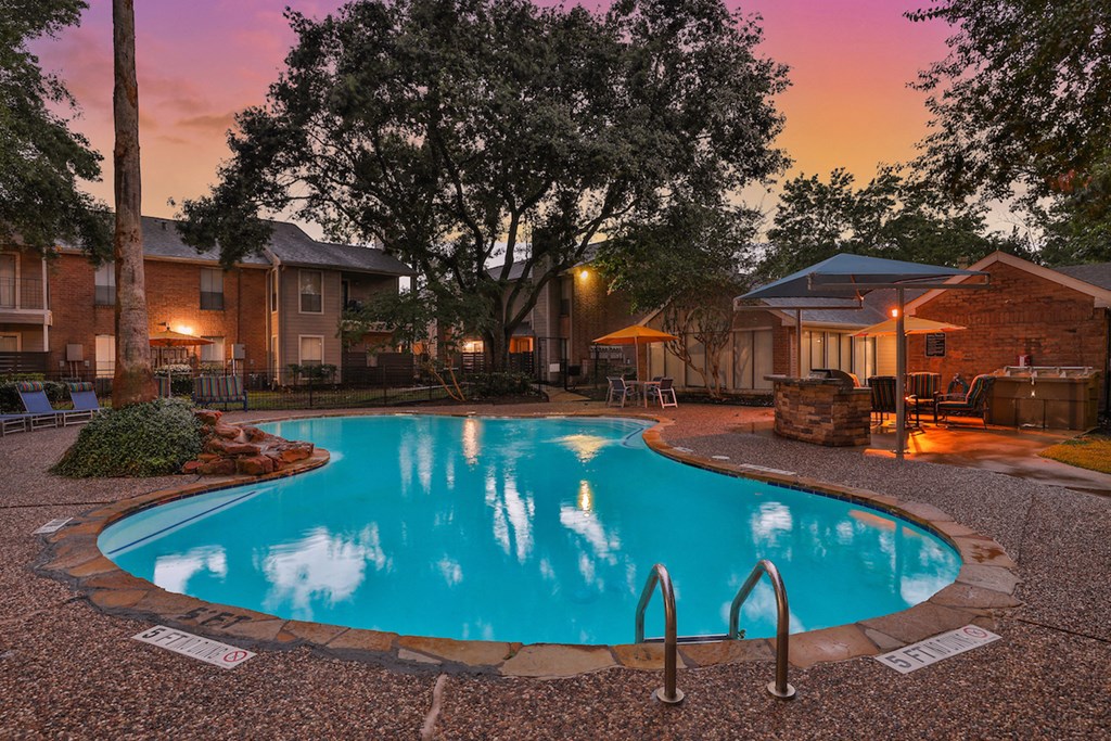 a swimming pool in front of a house at dusk
