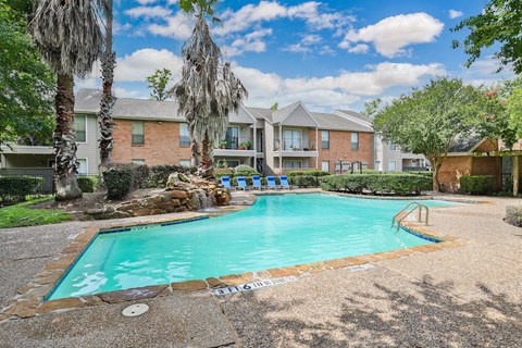 a swimming pool with trees and a building in the background