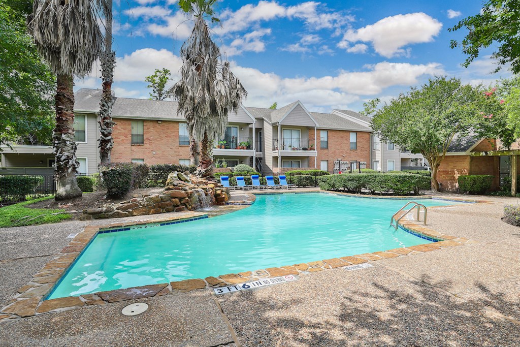 a swimming pool with trees and a building in the background