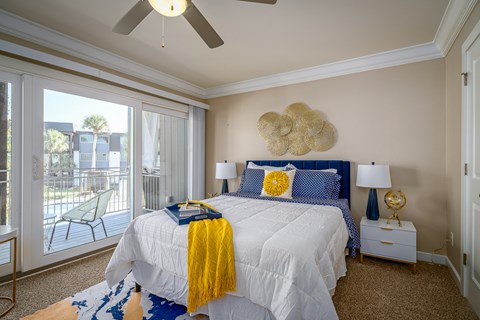 a bedroom with a large bed and a ceiling fan