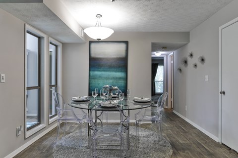 A dining room with a glass table and chairs.