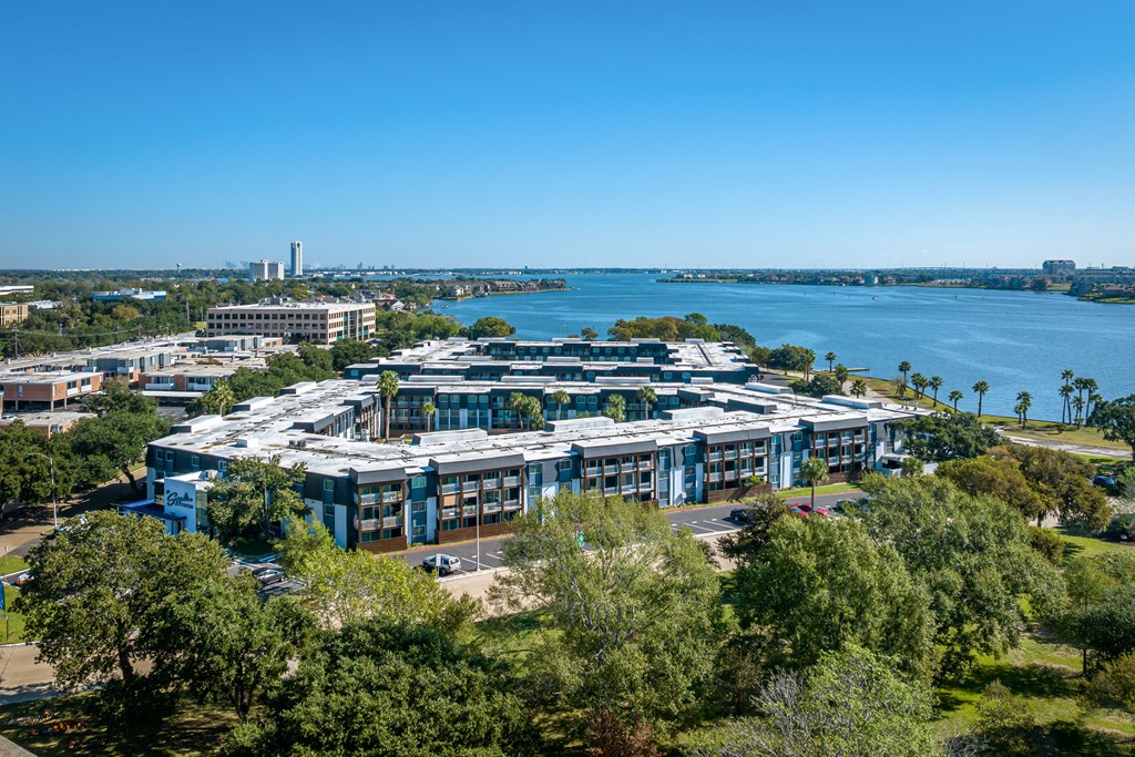 an aerial view of a building with a lake in the background