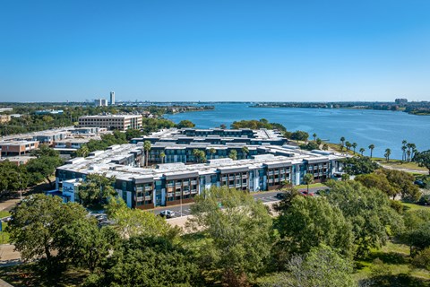 an aerial view of a building with a lake in the background