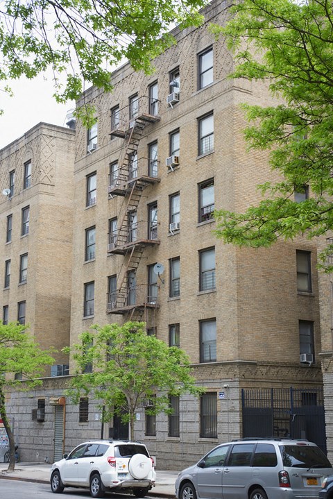 A tall brick building with a fire escape on the side.