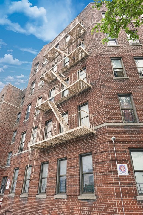 A red brick building with a white balcony on the second floor.