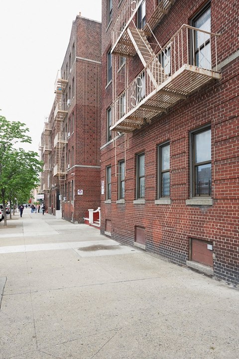 A long brick building with a fire escape.