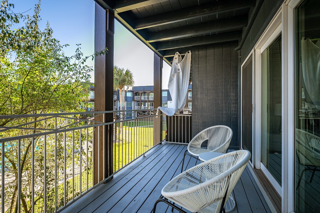 a balcony with two chairs and an umbrella on it