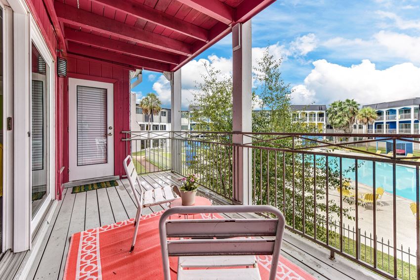 a balcony with a chair and a view of a body of water