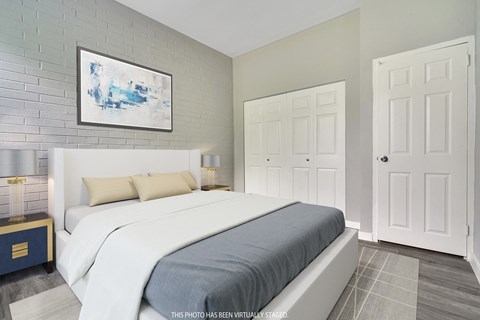 A bedroom with a large bed and a painting on the wall.