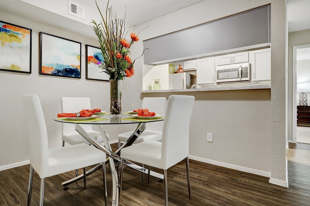 a dining area with a table and chairs and a kitchen