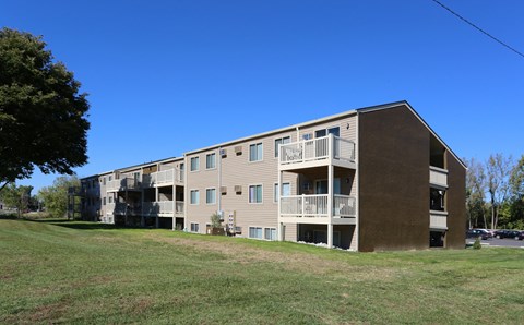 A large apartment building with a grassy area in front.
