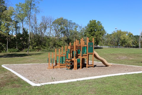A playground with a slide and a wooden structure.