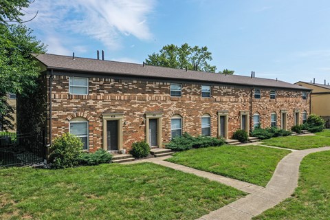 A brick building with a green lawn in front.