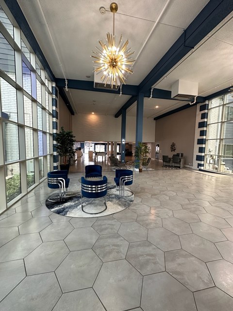 a large lobby with a chandelier and blue chairs