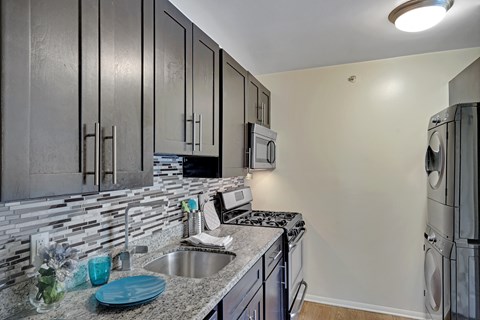 A modern kitchen with dark wood cabinets and stainless steel appliances.